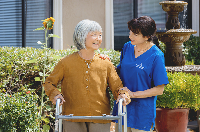Caregiver helping a senior client walk outside